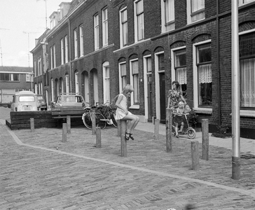 857245 Gezicht in de als leefstraat ingerichte Hennepstraat te Utrecht, met plantenbakken, bankjes en speeltoestellen.